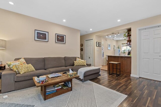 living area featuring dark wood-type flooring, recessed lighting, baseboards, and rail lighting