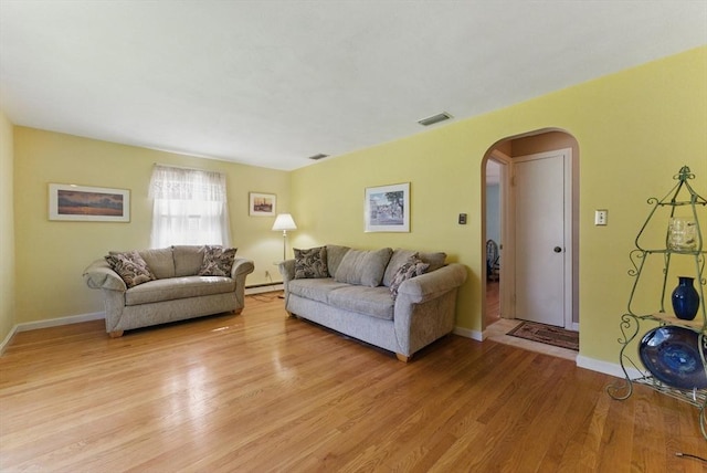 31 Fallston St, Springfield, MA 01119 - living room featuring arched walkways, light wood-style floors, baseboards, and a baseboard radiator