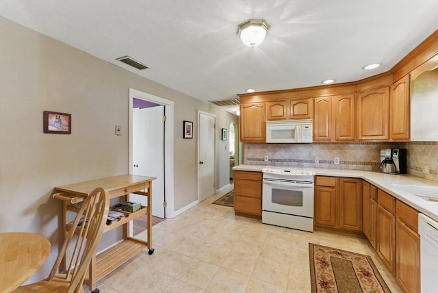 31 Fallston St, Springfield, MA 01119 - kitchen featuring white appliances, backsplash, light countertops, light tile patterned floors, and brown cabinets