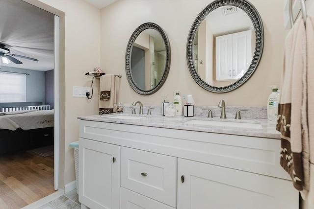 ensuite bathroom featuring ensuite bathroom, double vanity, a sink, and a ceiling fan