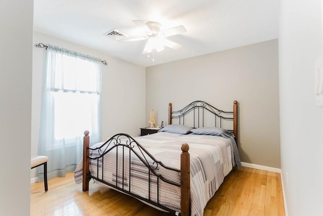 bedroom with multiple windows, light wood-type flooring, and visible vents