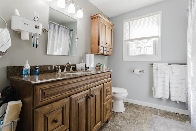 bathroom featuring toilet, baseboards, and vanity