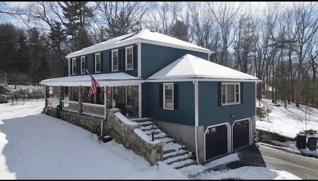 view of front of home featuring covered porch, driveway, and a garage