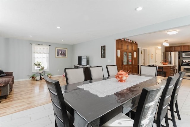 dining space featuring baseboards, light tile patterned flooring, and recessed lighting