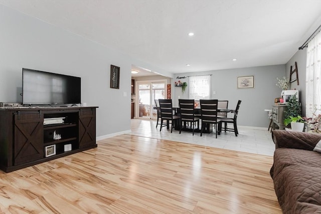 living area with light wood-type flooring, baseboards, and recessed lighting