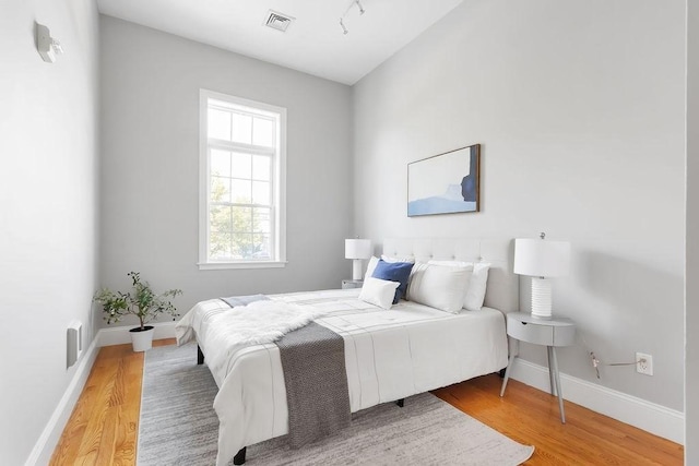 bedroom with wood finished floors and baseboards
