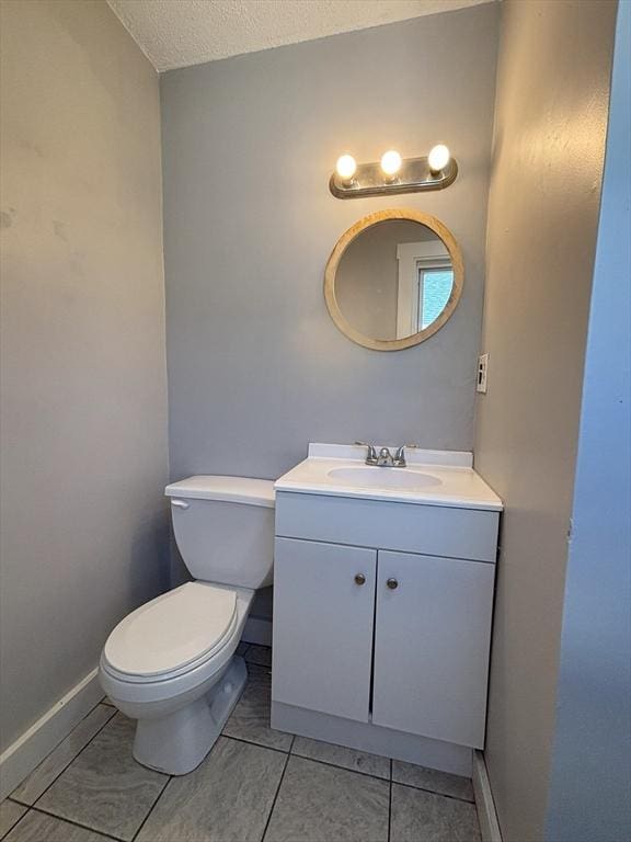 723 White St, Springfield, MA 01108 - half bathroom featuring vanity, toilet, tile patterned floors, a textured ceiling, and baseboards
