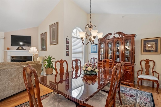 31 Shaker Hill Rd Unit 31, Hooksett, NH 03106 - dining area featuring vaulted ceiling, a chandelier, wood finished floors, and a fireplace