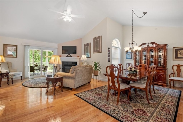 31 Shaker Hill Rd Unit 31, Hooksett, NH 03106 - dining area with vaulted ceiling, a glass covered fireplace, light wood-style floors, and a ceiling fan
