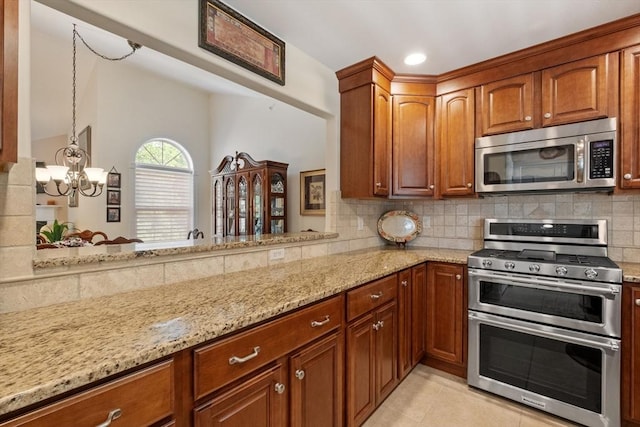 31 Shaker Hill Rd Unit 31, Hooksett, NH 03106 - kitchen with stainless steel appliances, light stone counters, a chandelier, decorative backsplash, and brown cabinetry