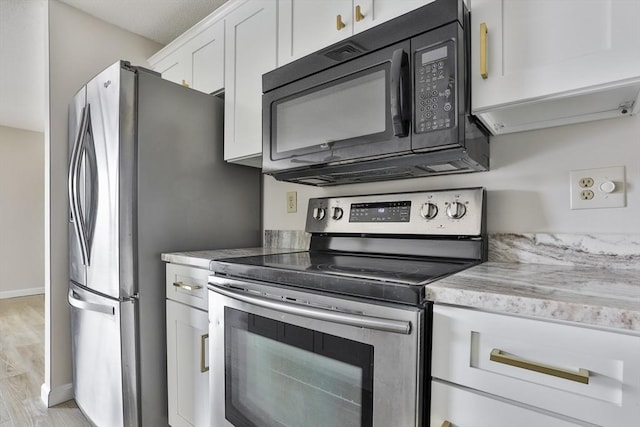 kitchen with baseboards, light stone countertops, light wood-style flooring, white cabinets, and stainless steel appliances