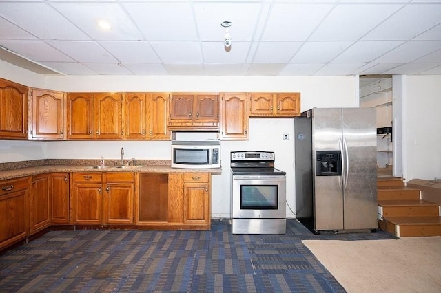 135 Elm St, Southbridge, MA 01550 - kitchen featuring appliances with stainless steel finishes, brown cabinetry, dark carpet, and a drop ceiling