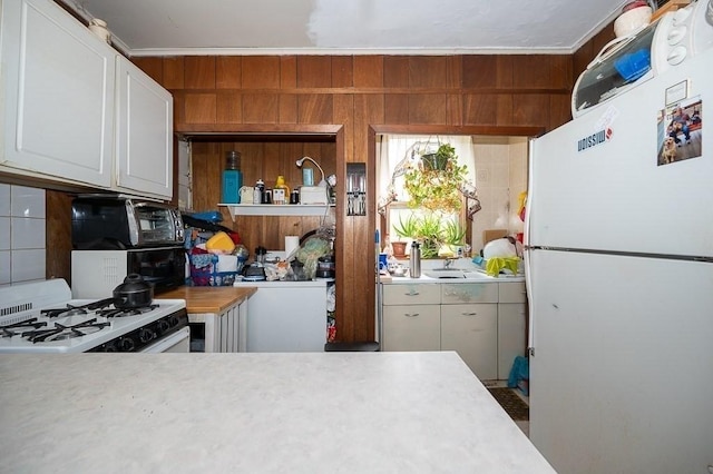 135 Elm St, Southbridge, MA 01550 - kitchen featuring white appliances, light countertops, white cabinetry, wood walls, and tasteful backsplash