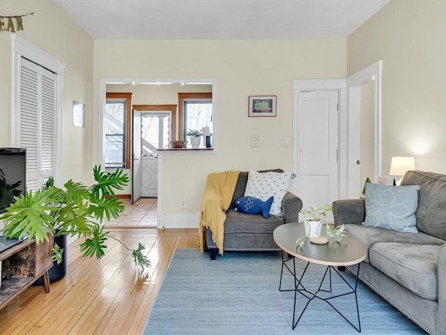 living area featuring light wood-style floors and baseboards