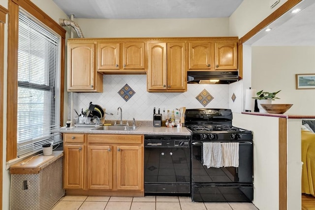 kitchen with black appliances, light countertops, a sink, and under cabinet range hood
