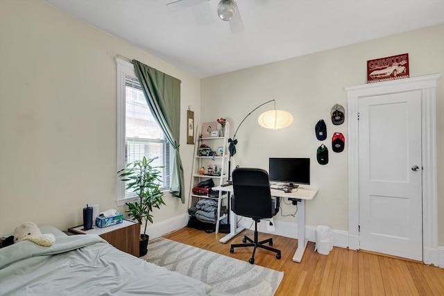 bedroom featuring ceiling fan, light wood-style flooring, and baseboards