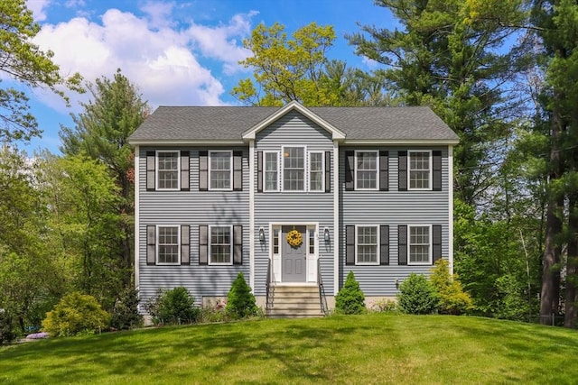 colonial home with a front yard and entry steps