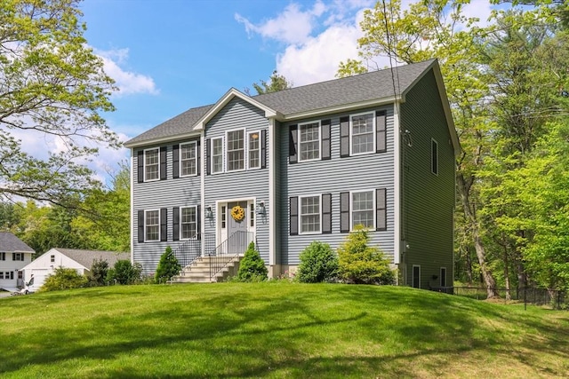 colonial house featuring a front lawn and entry steps