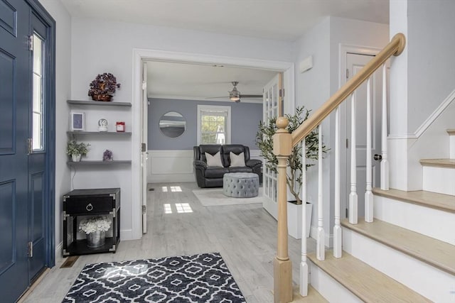 foyer featuring stairway, a ceiling fan, and light wood-style floors