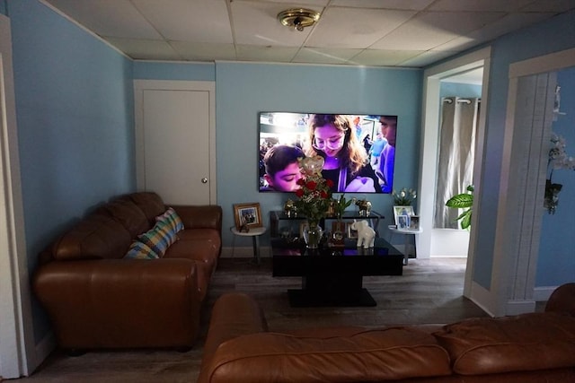 living room featuring wood finished floors, a paneled ceiling, and baseboards