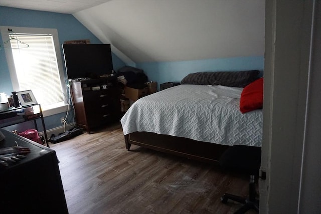 bedroom featuring lofted ceiling and wood finished floors
