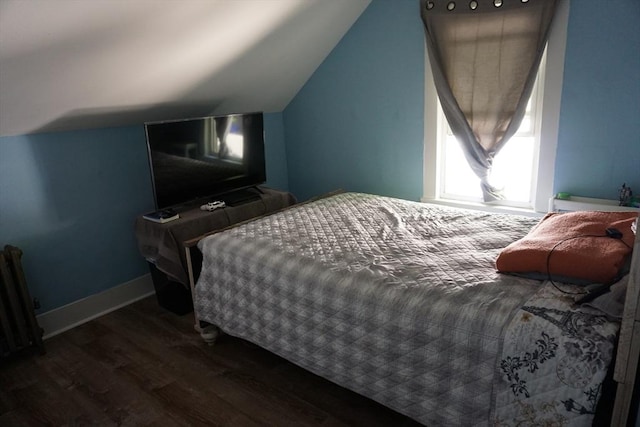 bedroom with wood finished floors, vaulted ceiling, and baseboards