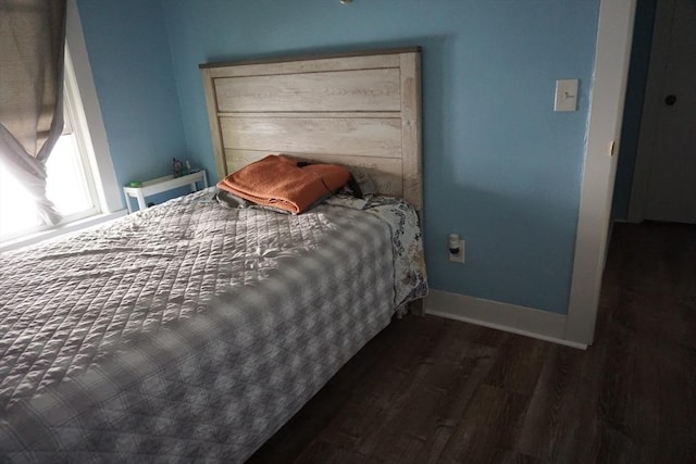 bedroom featuring wood finished floors and baseboards