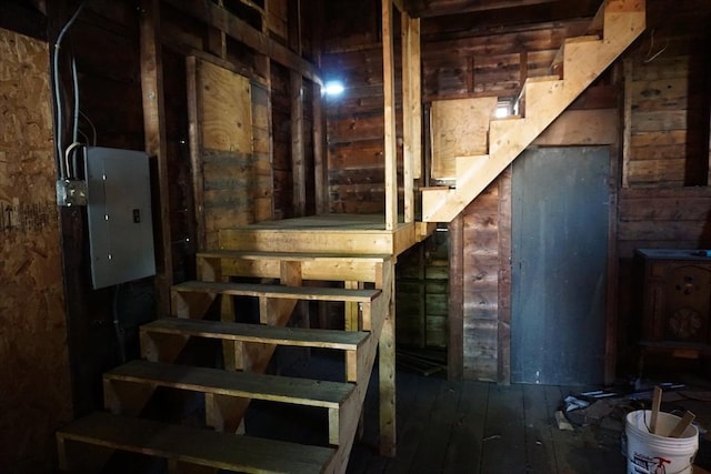 staircase with electric panel and wood-type flooring