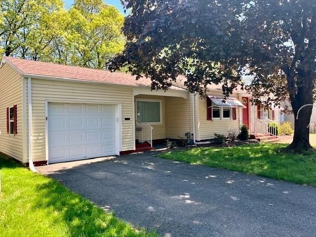 view of front of property featuring a garage, asphalt driveway, and a front lawn