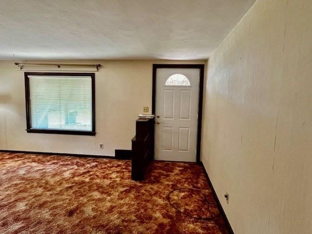 foyer featuring carpet floors and baseboards