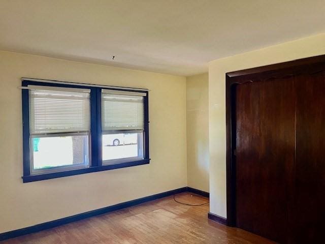 empty room with baseboards and wood finished floors