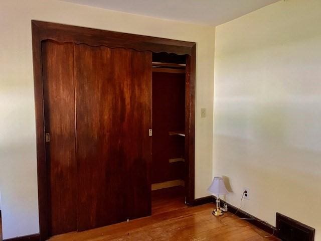 bedroom with wood finished floors and baseboards