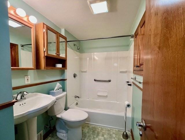 bathroom with toilet,  shower combination, and a sink