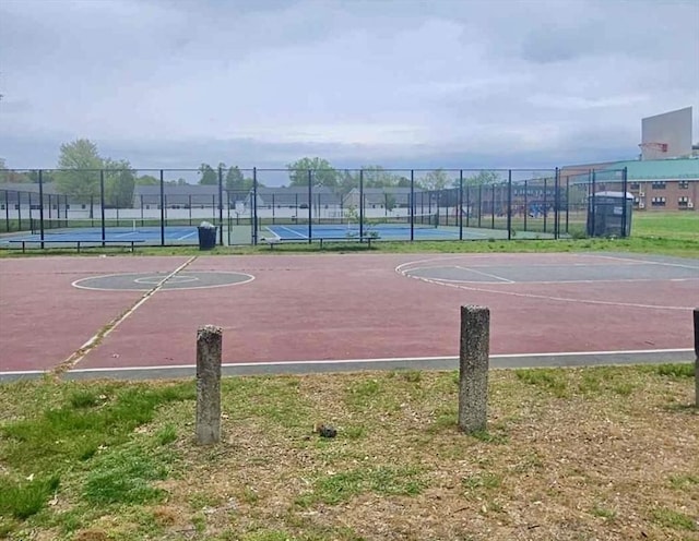 view of sport court with a tennis court, community basketball court, and fence