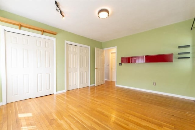 5 Linda Ln Unit 2-2, Boston, MA 02125 - unfurnished bedroom with two closets, wood finished floors, baseboards, and track lighting