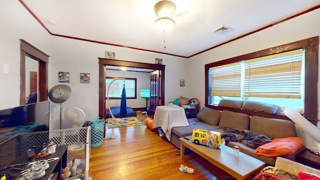 living room featuring ornamental molding and light wood-type flooring