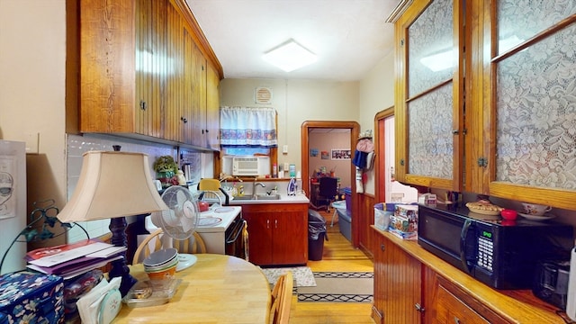 kitchen featuring light wood-type flooring, cooling unit, sink, and range