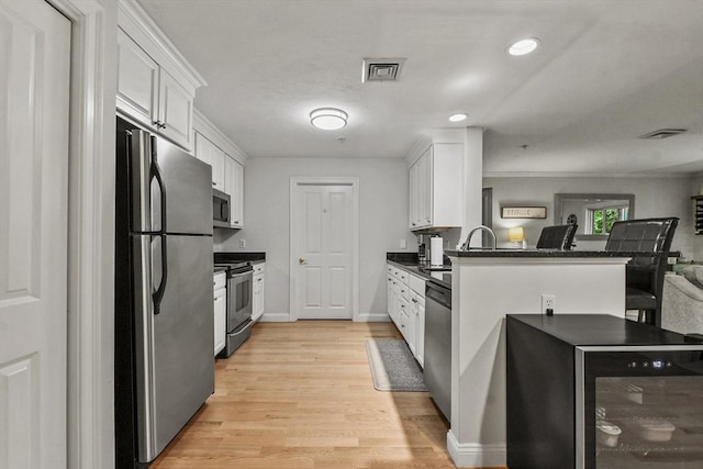 29 Maple St Unit C, Canton, MA 02021 - kitchen featuring stainless steel appliances, dark countertops, white cabinetry, a peninsula, and recessed lighting