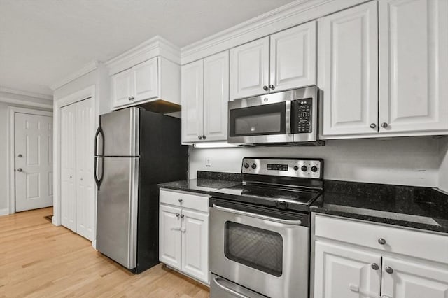 29 Maple St Unit C, Canton, MA 02021 - kitchen featuring appliances with stainless steel finishes, white cabinetry, light wood-style flooring, dark stone countertops, and crown molding
