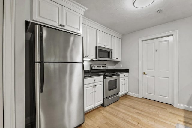 29 Maple St Unit C, Canton, MA 02021 - kitchen with stainless steel appliances, white cabinetry, dark countertops, and light wood-style flooring