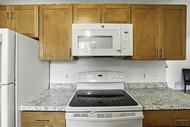 205 Bayberry Hill Ln Unit 205, Leominster, MA 01453 - kitchen featuring white appliances, brown cabinetry, and light stone counters