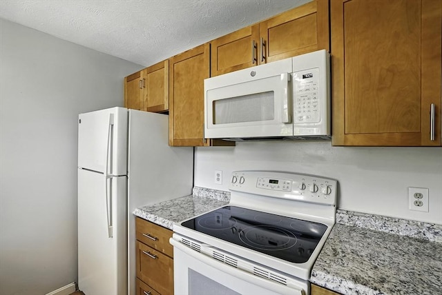 205 Bayberry Hill Ln Unit 205, Leominster, MA 01453 - kitchen featuring white appliances, brown cabinets, and a textured ceiling