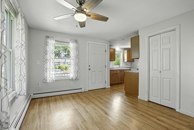 205 Bayberry Hill Ln Unit 205, Leominster, MA 01453 - kitchen with a baseboard radiator, light countertops, light wood-style flooring, and brown cabinets