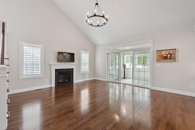 16 Dean Ln Unit 16, Littleton, MA 01460 - unfurnished living room with high vaulted ceiling, a chandelier, wood finished floors, a glass covered fireplace, and baseboards