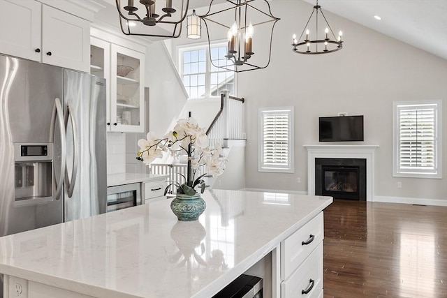 16 Dean Ln Unit 16, Littleton, MA 01460 - kitchen with a chandelier, stainless steel fridge, a glass covered fireplace, high vaulted ceiling, and open floor plan