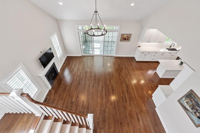 16 Dean Ln Unit 16, Littleton, MA 01460 - unfurnished living room featuring a chandelier, dark wood-style floors, a fireplace, baseboards, and recessed lighting