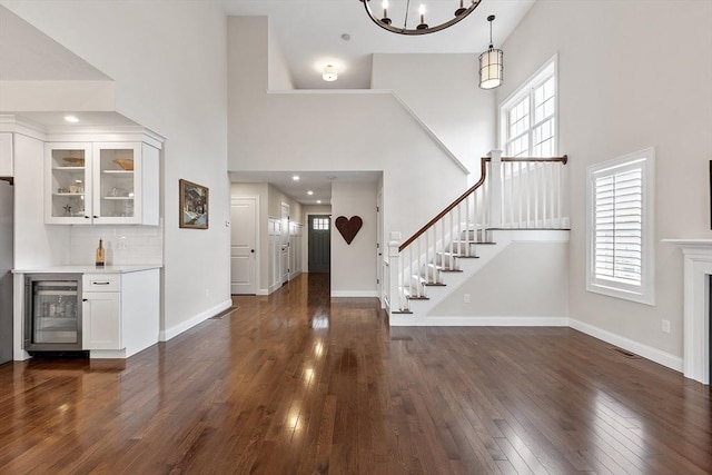 16 Dean Ln Unit 16, Littleton, MA 01460 - foyer with wine cooler, a towering ceiling, dark wood-type flooring, bar, and stairway