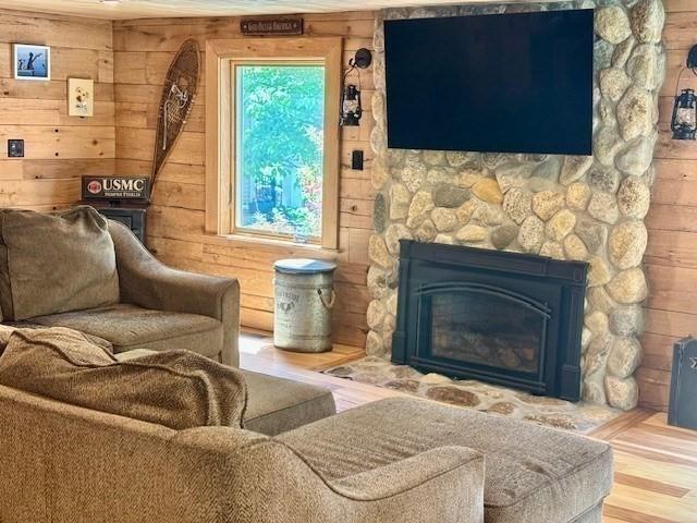 80 Populatic St, Franklin, MA 02038 - living area with a fireplace, wood finished floors, and wood walls