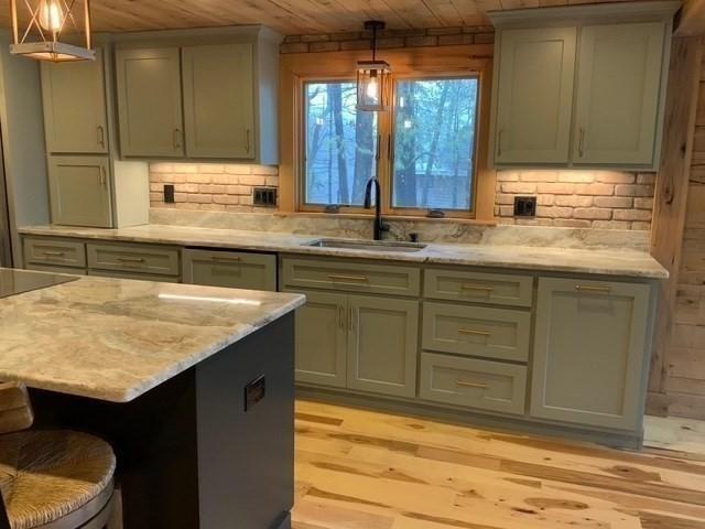80 Populatic St, Franklin, MA 02038 - kitchen featuring a sink, wooden ceiling, light wood-style flooring, a kitchen breakfast bar, and light stone counters