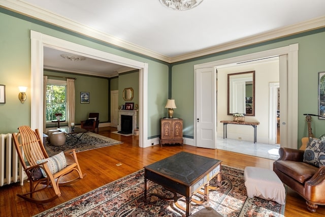 sitting room with crown molding and wood-type flooring